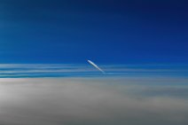 Aircraft in flight - with vapor trail - above clouds Aircraft in flight - with vapor trail - above clouds.jpg