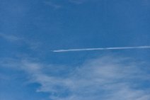 Aircraft with vapor trail in blue sky Aircraft with vapor trail in blue sky.JPG